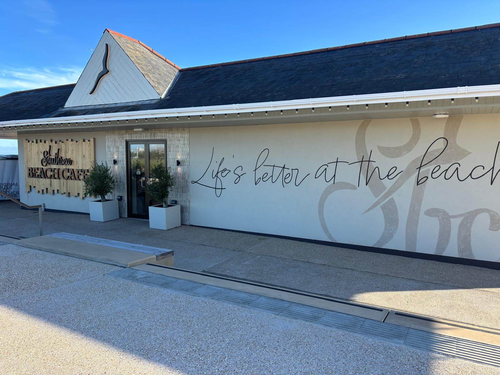 The exterior of Southsea Beach Cafe showing their sign and motto Life's better at the beach 
